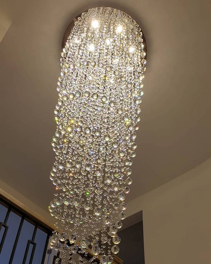 Lit crystal chandelier viewed from below in a two-storey entryway